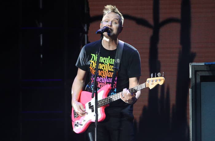 Mark plays a pink guitar while singing onstage