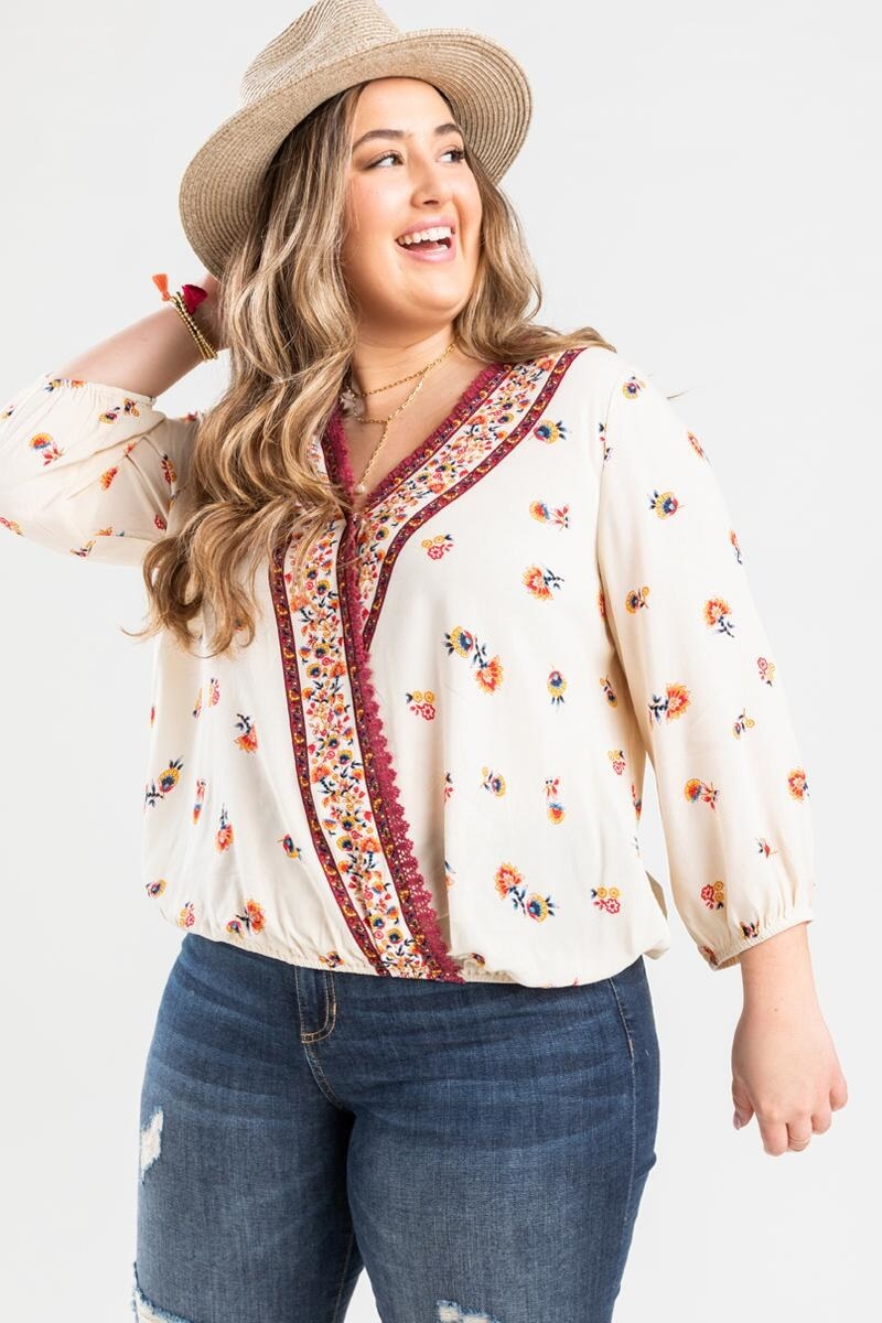 model wearing white long-sleeve floral blouse with multicolored flowers and trim