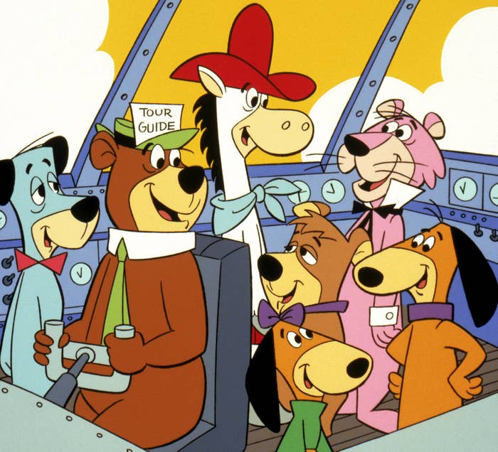 Yogi Bear, wearing a &quot;Tour Guide&quot; hat, with Huckleberry Hound, Snagglepuss, and other Hanna-Barbera characters