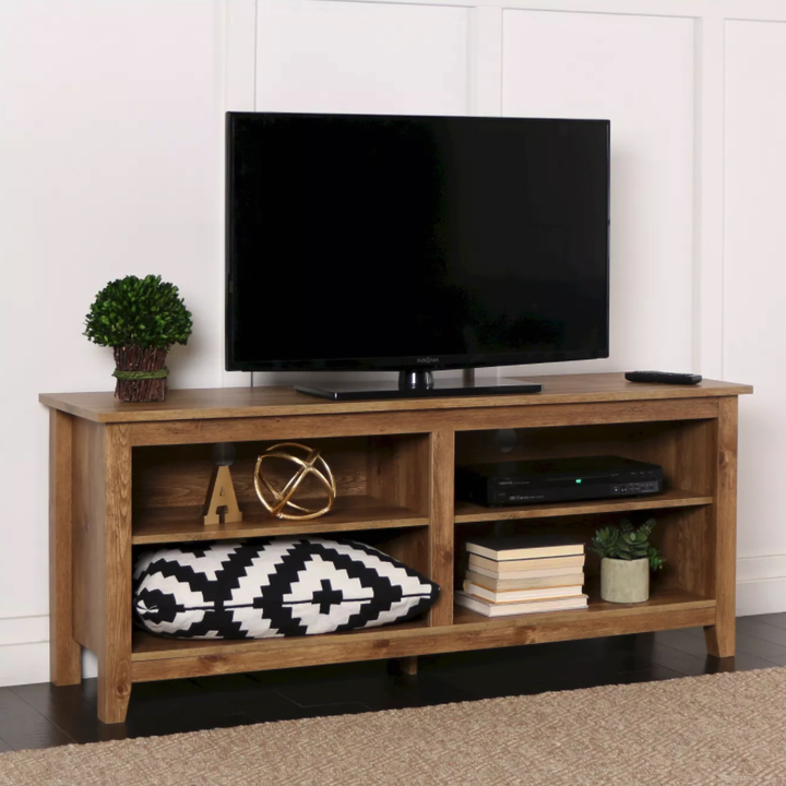 wooden tv stand with a TV on top and four shelves inside 