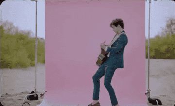 约书亚巴弹吉他,前面的外面,一个粉红色的背景