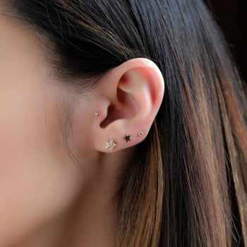 a model with the gold star earrings in their ear 