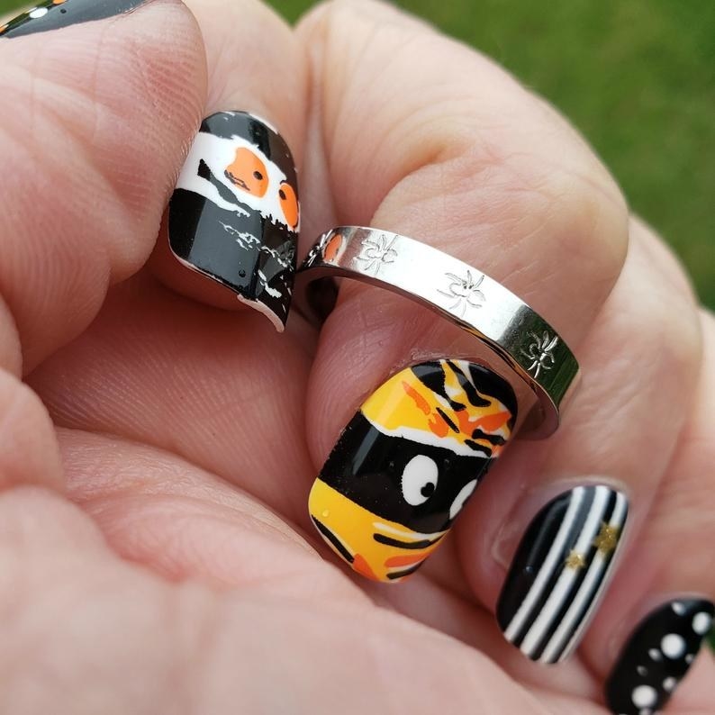 a model with Halloween nails on, wearing the silver ring with spiders on it