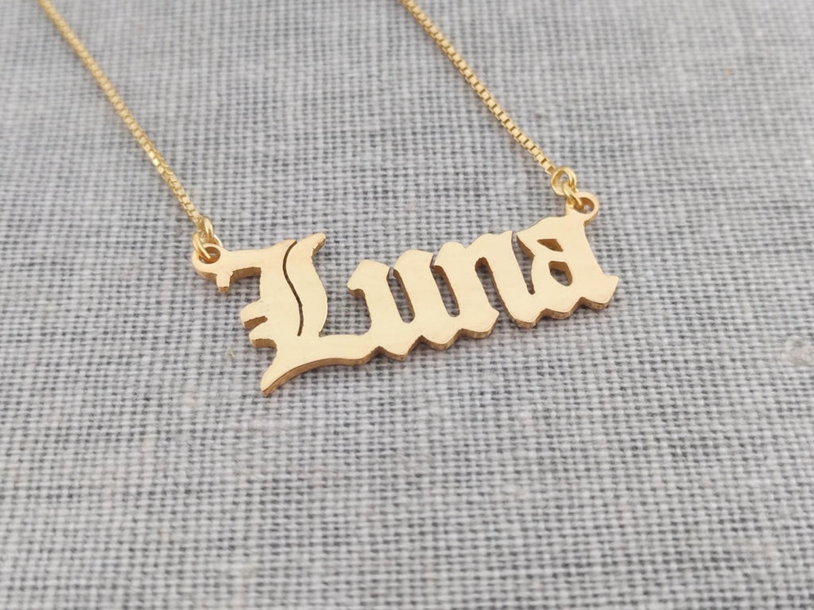 a gold necklace with the name &quot;Luna&quot; in Old English font
