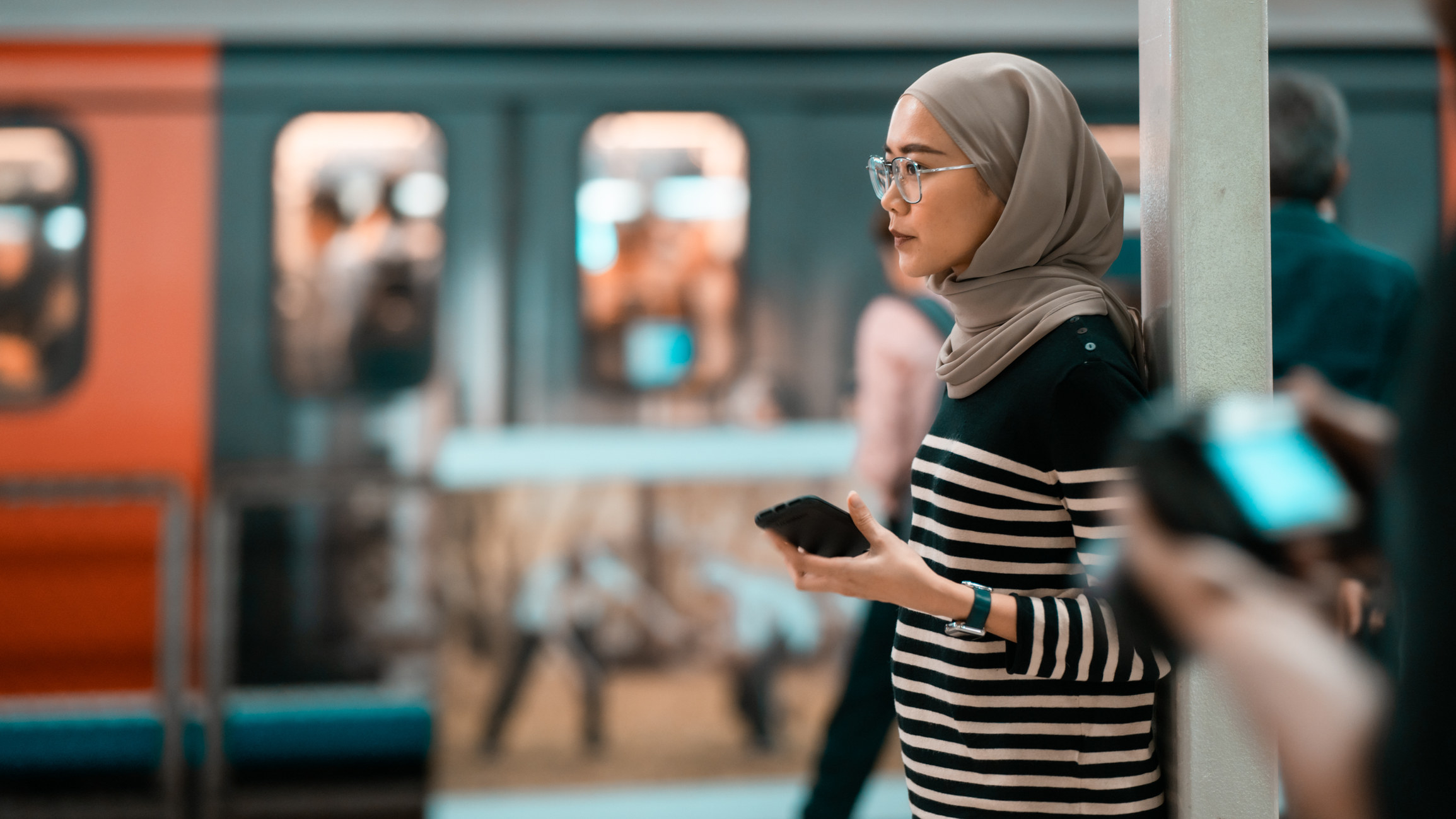 A Muslim woman at a train station