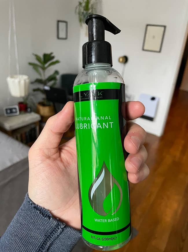 Model holding green bottle of Lynk personal lubricant
