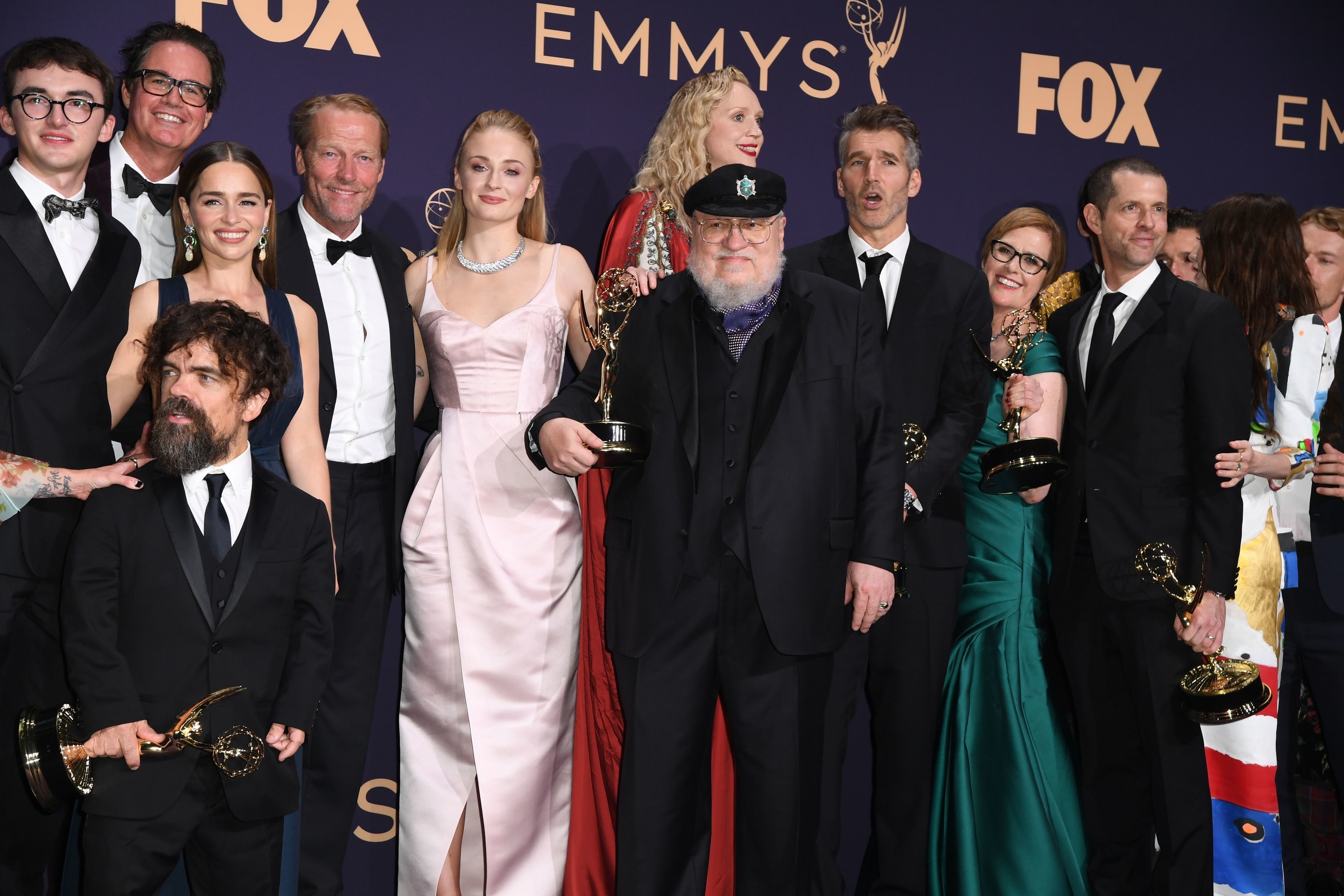 George holds up an Emmy while surrounded by the cast at the awards show