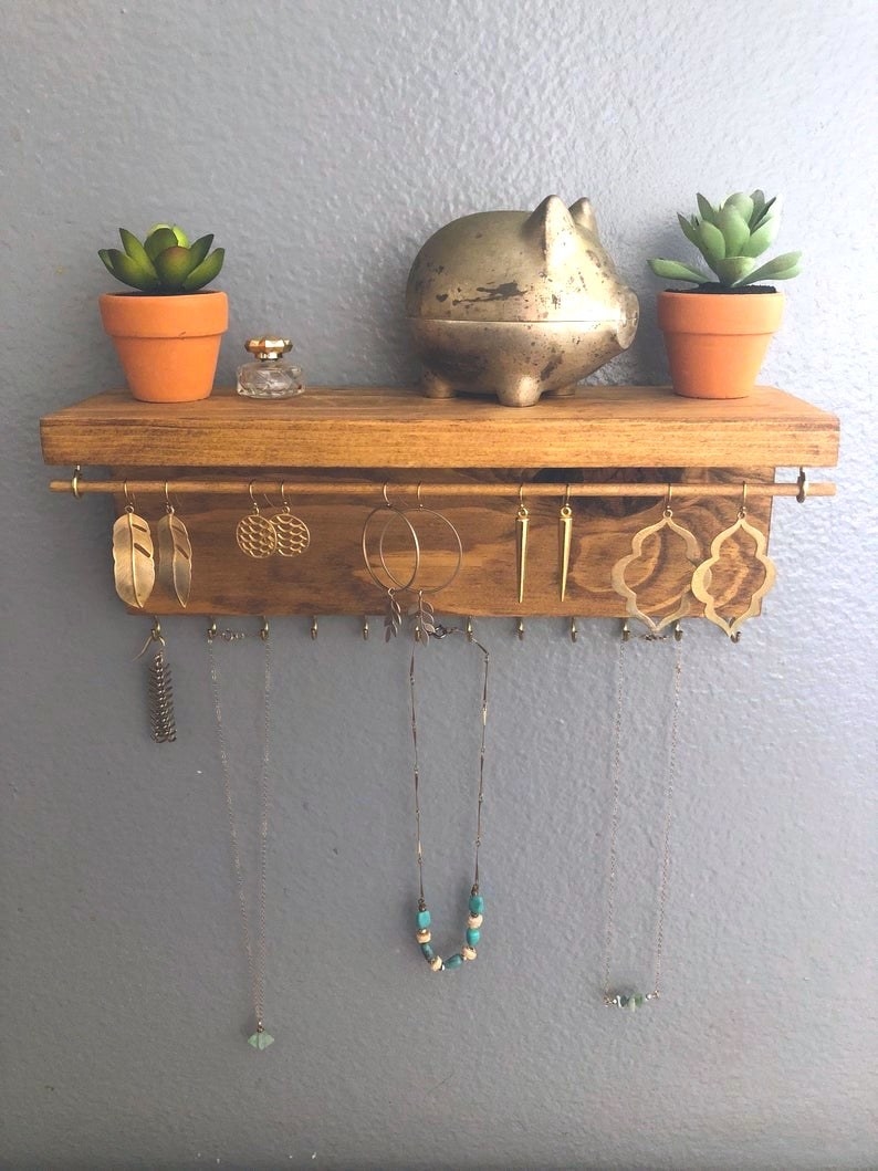 wooden shelf with hooks holding necklaces and earrings