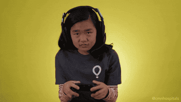 Young girl with headphones on and manipulating a game controller
