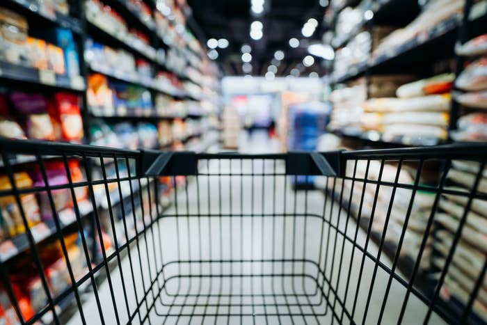 View out the back of a grocery cart in a blurred aisle