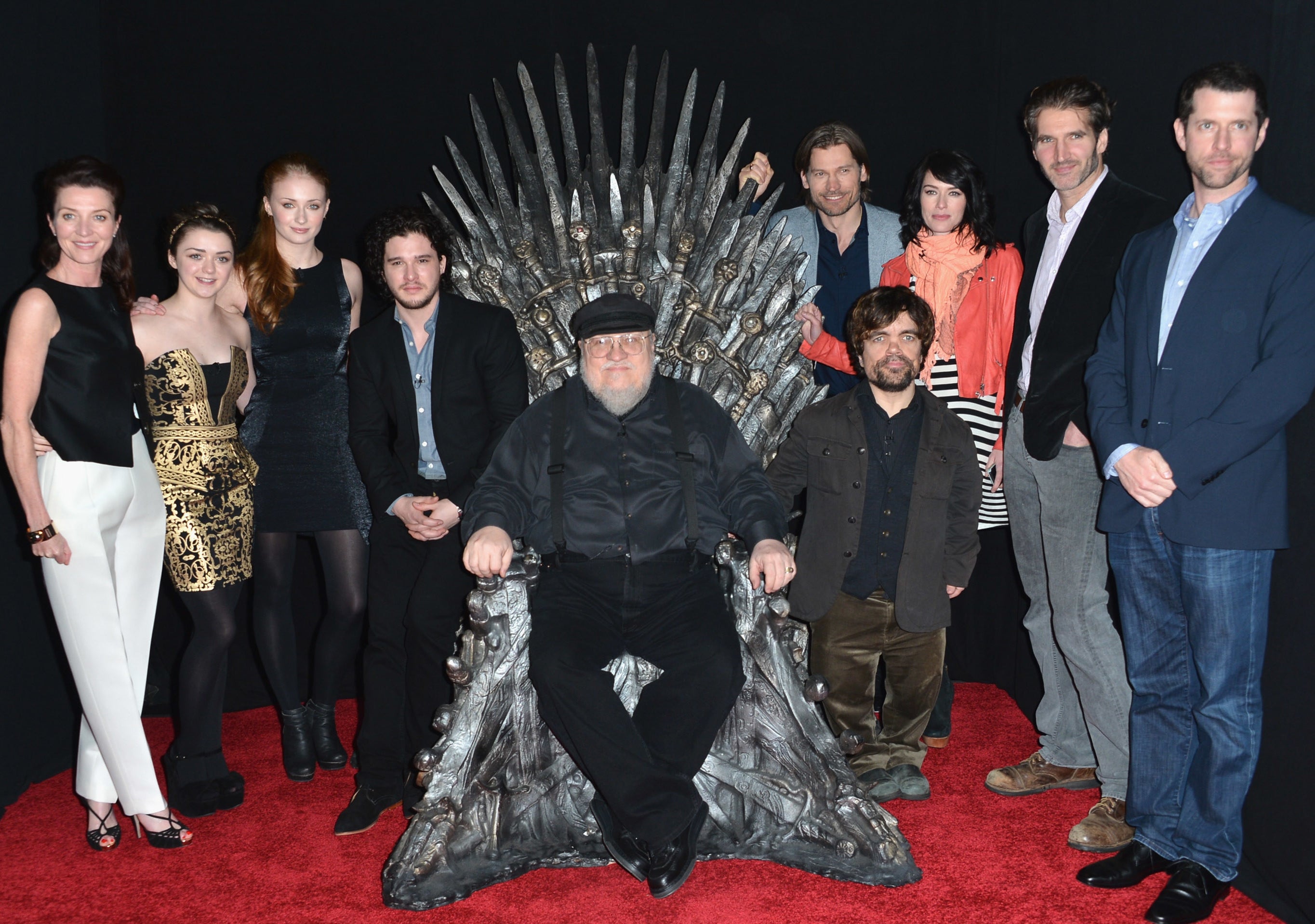 George sits on the throne while surrounded by the show's cast