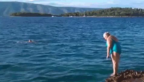 GIF de uma senhorinha pulando no mar de mau jeito
