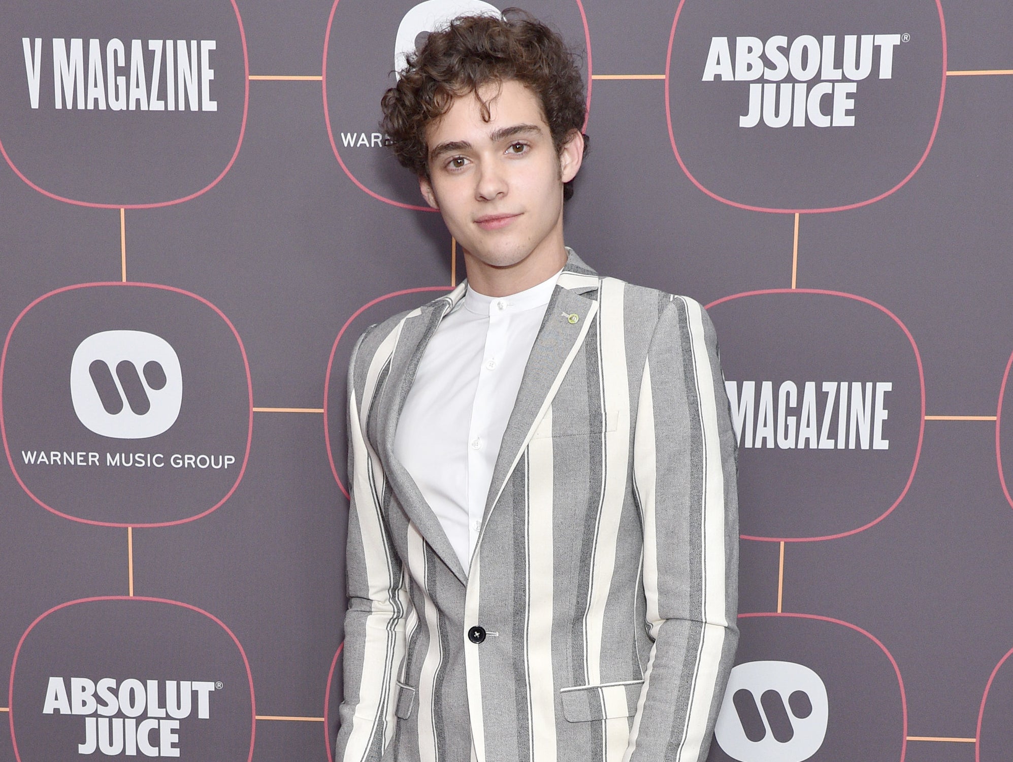 Joshua wears a striped blazer at an event