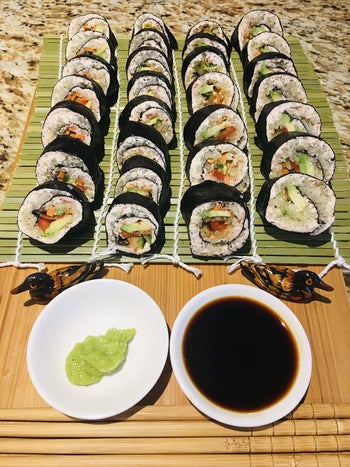 a reviewer photo of the sushi rolls sliced and a saucer of wasabi and soy sauce