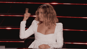 Ashley Tisdale smiles, points to her head, and mouths &quot;yup&quot; in this &quot;The Masked Dancer&quot; gif