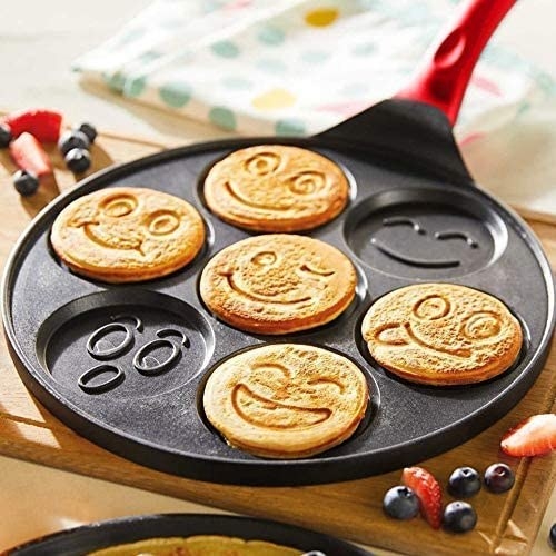 Emoji pancake griddle with smiley pancakes on a table
