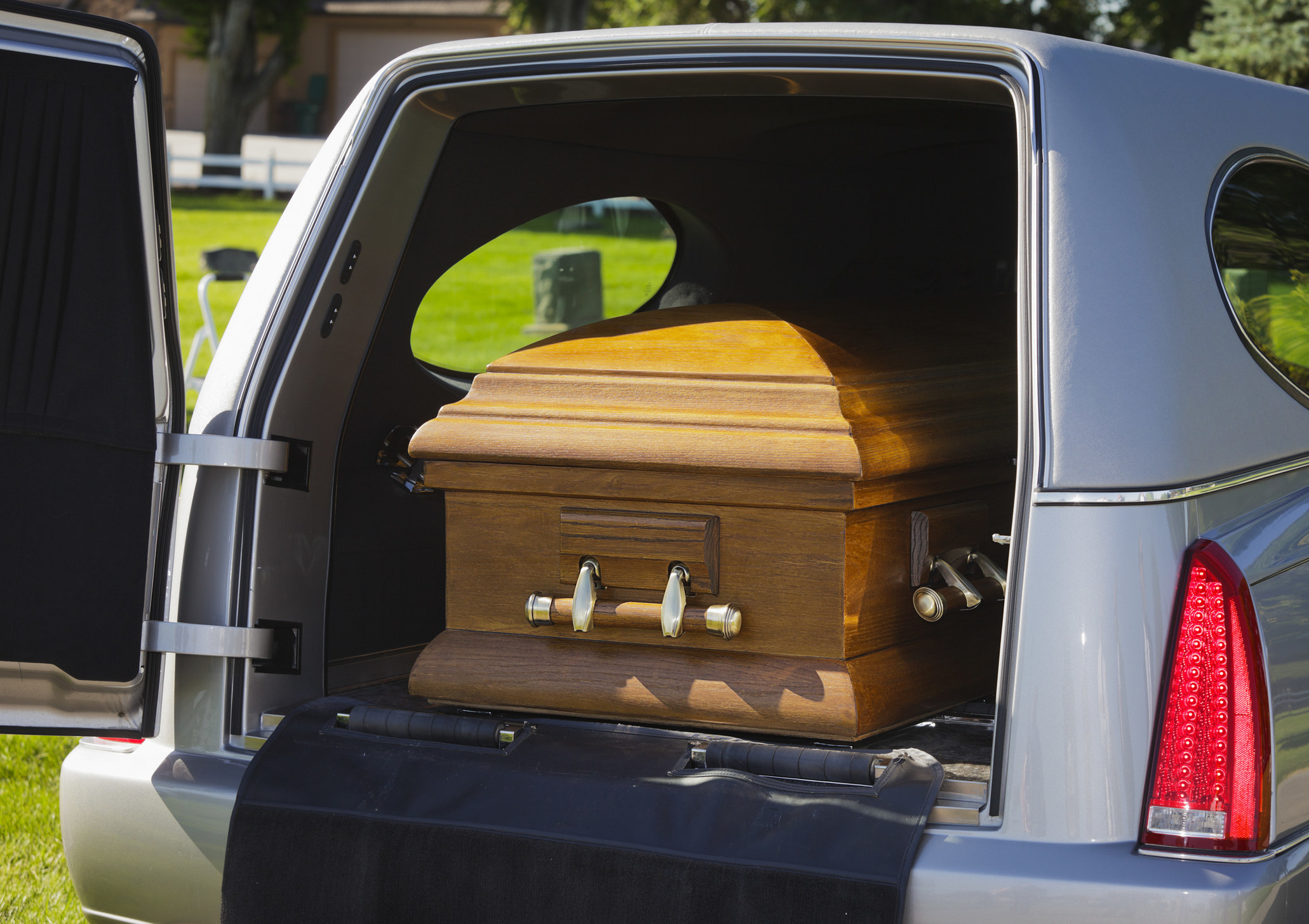 A casket in the backseat of a funeral hearse