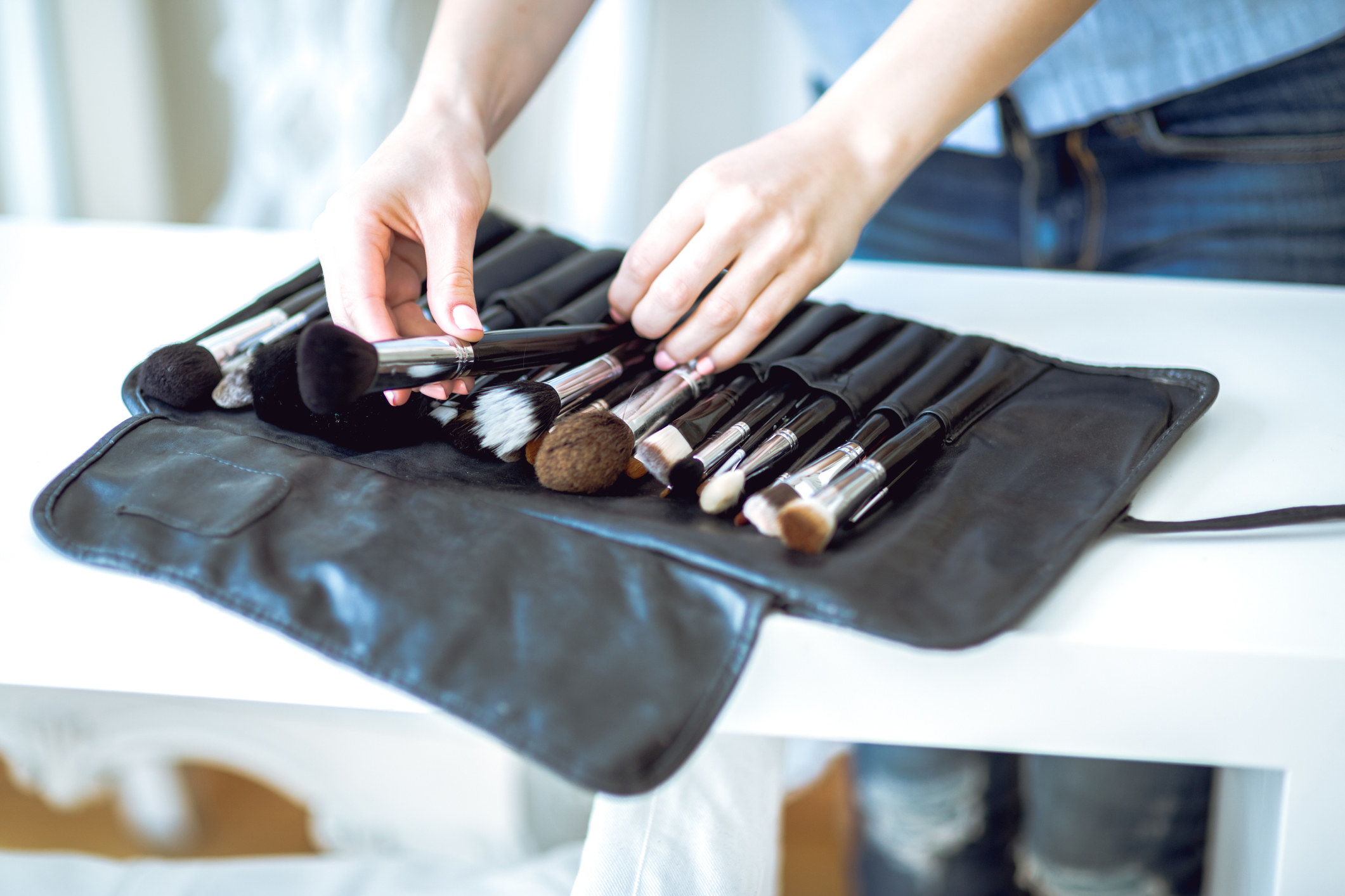 A makeup artist puts some brushes away in their kit