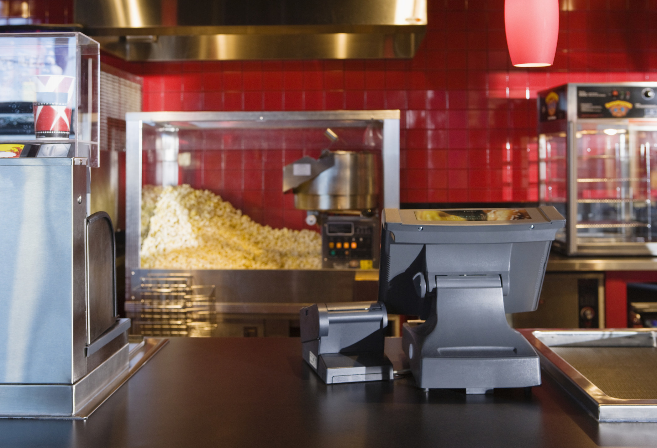 A concession stand at a movie theater, with a popcorn machine and a drink machine