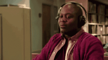 Titus from Unbreakable Kimmy Schmidt jamming out to music with headphones on