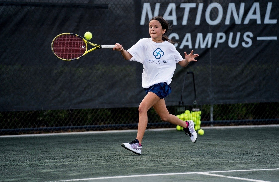 A young girl playing tennis