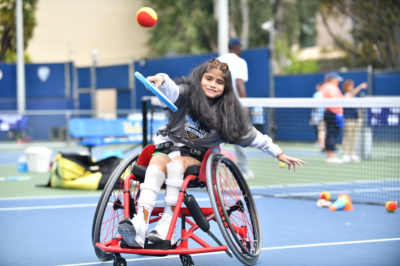 A young girl playing goalball in a wheelchair