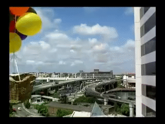 Napoleon the dog is a wicker crate, that is attached to balloons, flying over a city