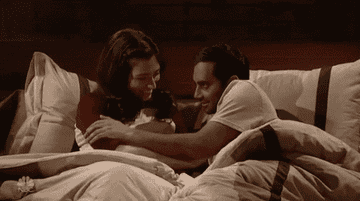 Aziz Ansari and Melissa Villasenor from SNL touching each other exaggeratedly in bed