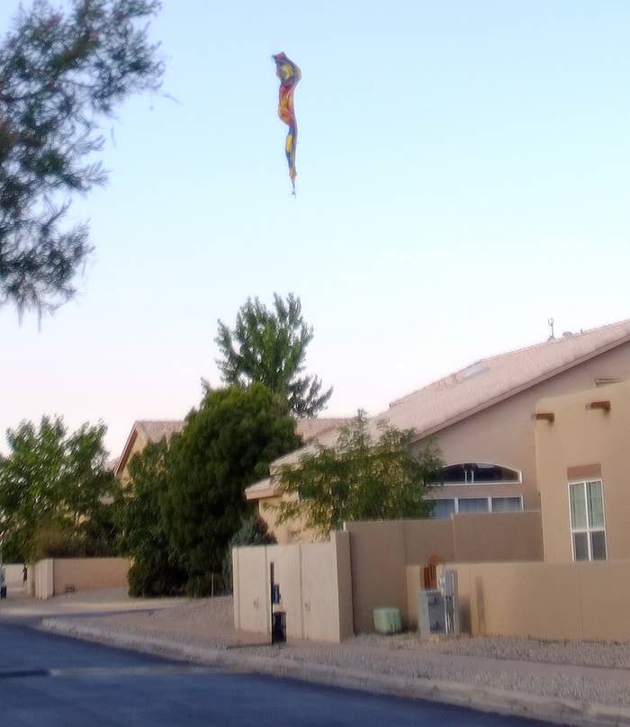 A remnant of the balloon descends toward a house
