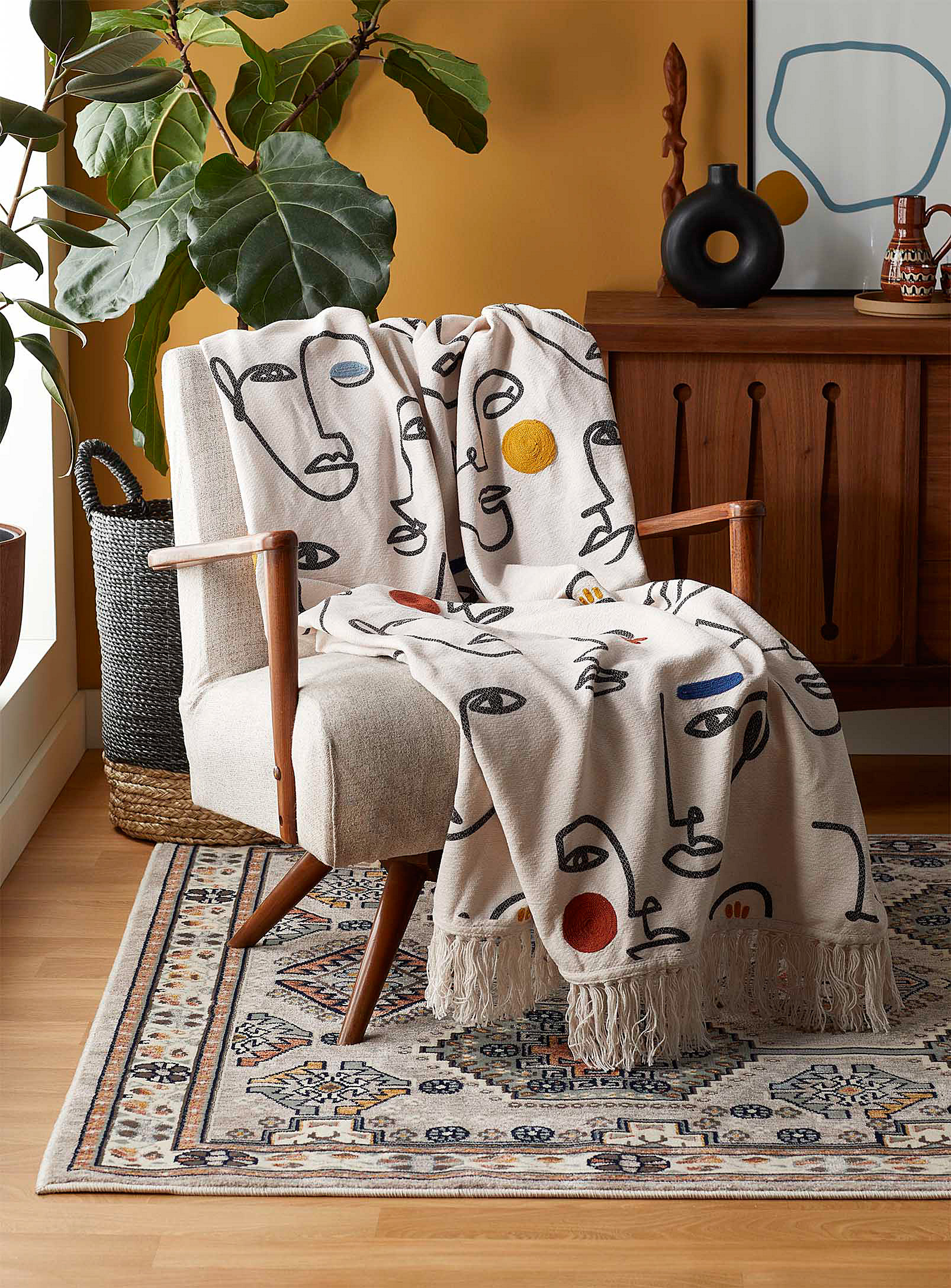A soft throw blanket is draped over a chair