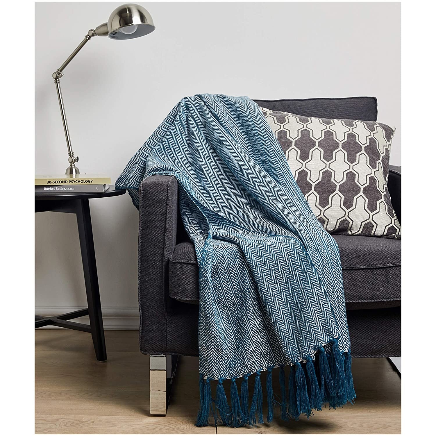 A blue chevron print throw blanket draped across a couch.
