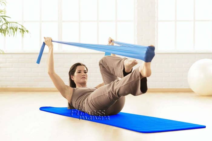 A woman exercising on blue yoga mat