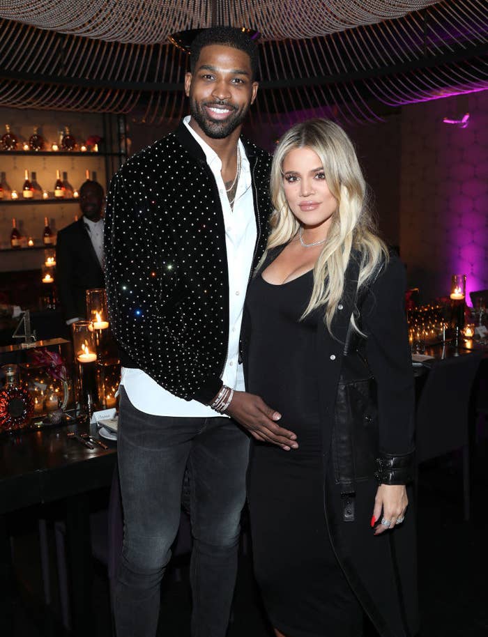 Tristan cradling Khloe&#x27;s baby bump as they pose for a photo