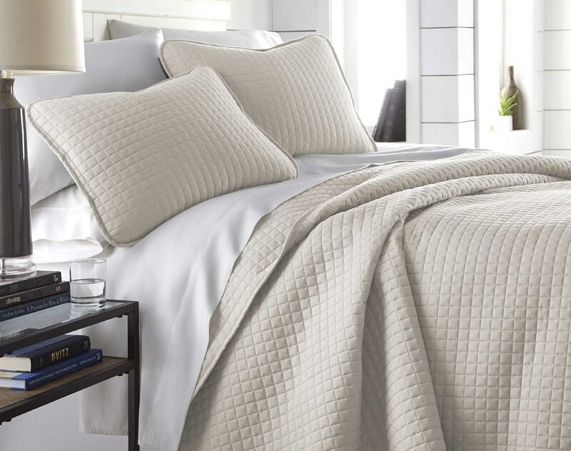 the quilt set in cream on a bed