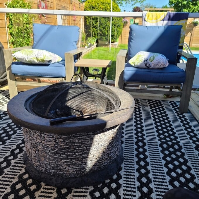 reviewer photo of the firepit next to two patio chairs
