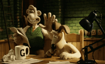Wallace and Gromit sitting at a table, Wallace is holding a newspaper and patting Gromit&#x27;s head