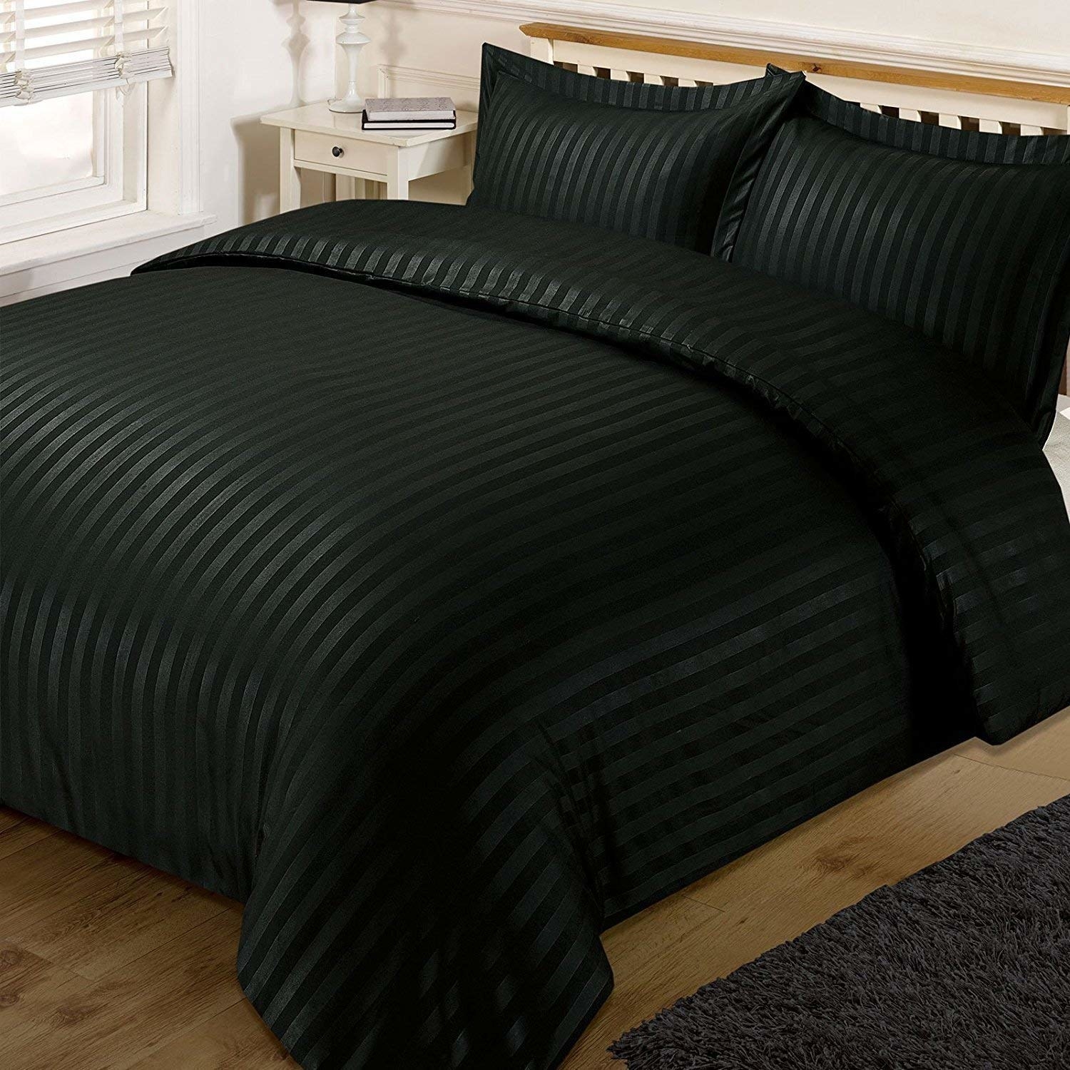 Black stain bedsheets with stripes pictured on a bed.