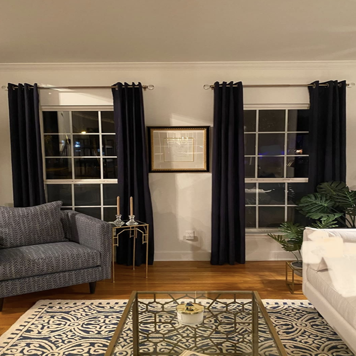 Reviewer's curtain rods are used to cover up two windows in a living room