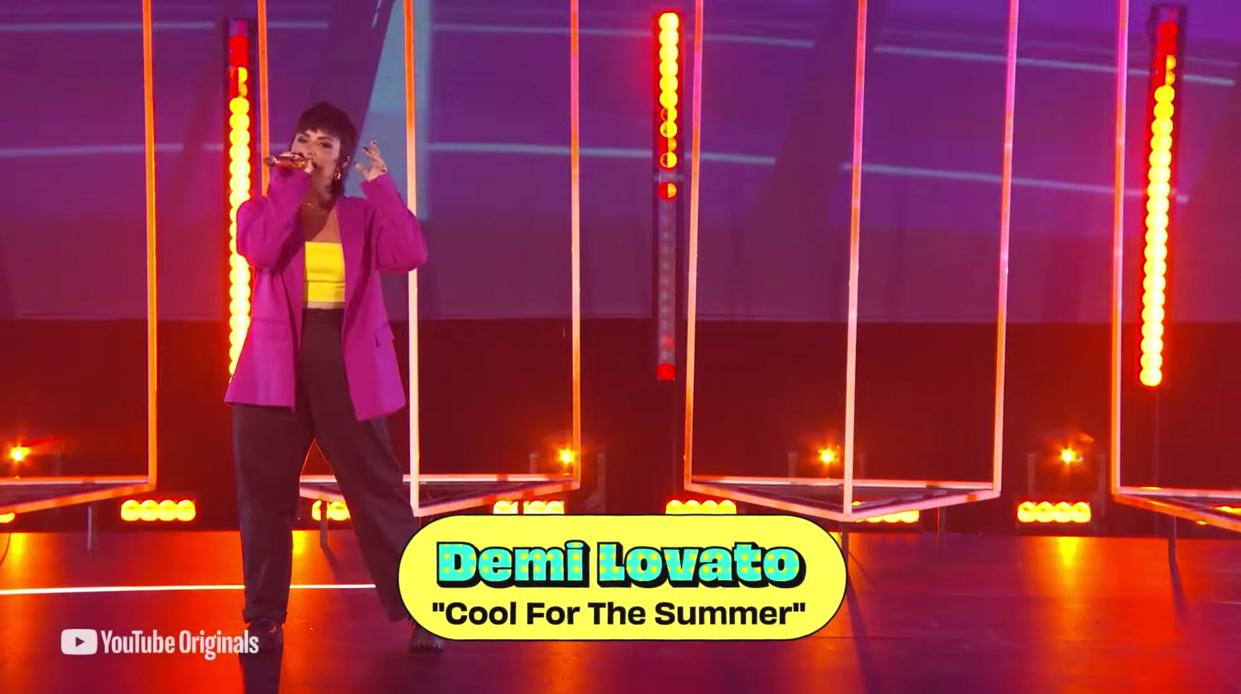 Lovato performs &quot;Cool for the Summer&quot; while wearing black pants, a yellor top, and a purple blazer