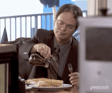 A GIF of Dwight from The Office pouring maple syrup on his waffles.