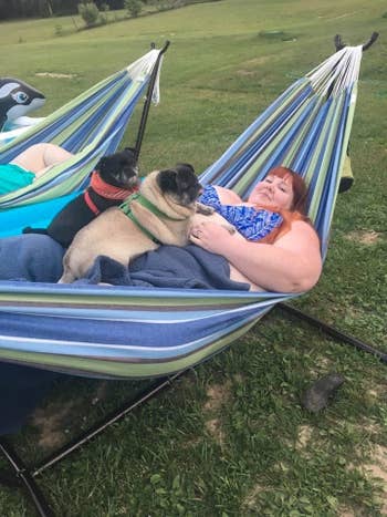 a reviewer and two of their dogs lounging in the tropical cotton vivere hammock
