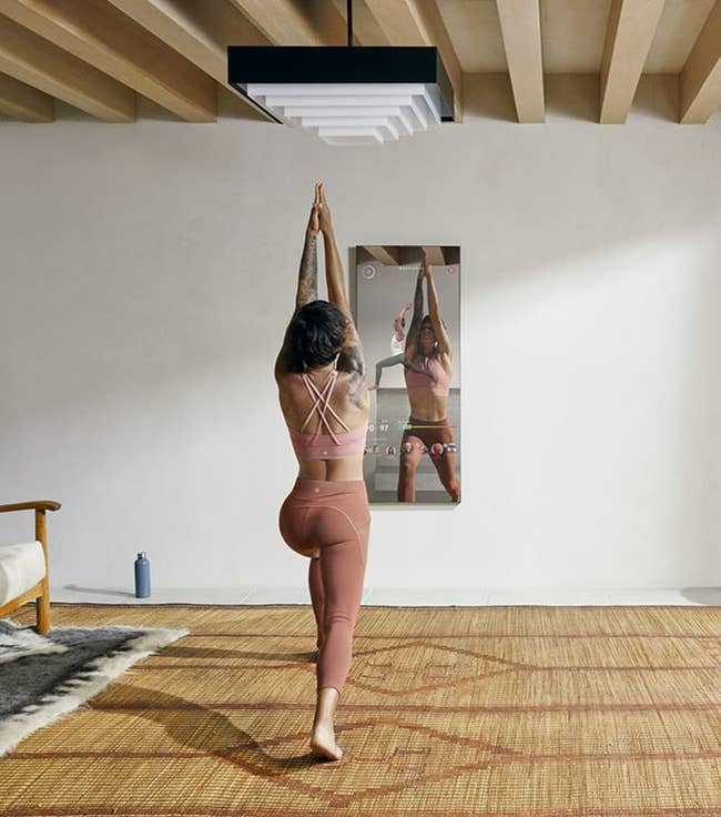 a model does yoga in front of the mirror