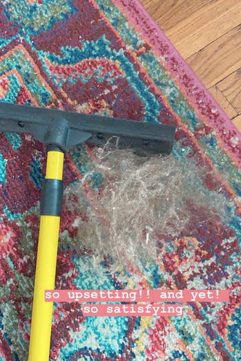 BuzzFeed Shopping reviewer's carpet with a hairball next to the broom and text reading 