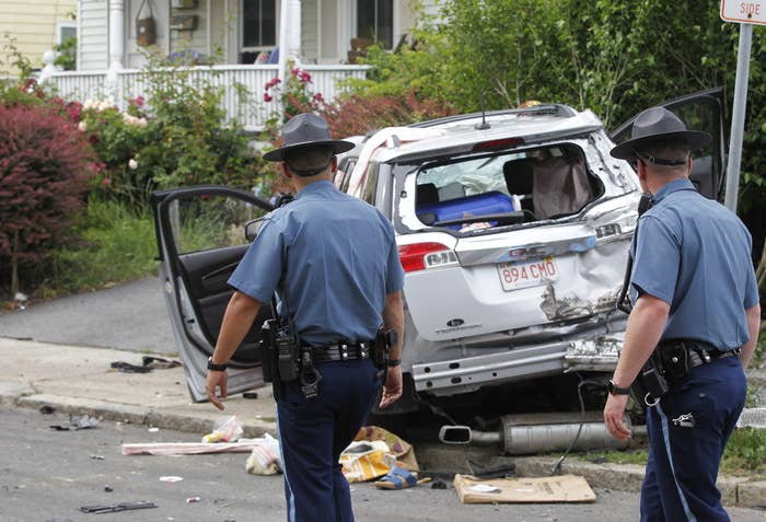 State troops are shown walking next to a battered SUV at the scene of the crime