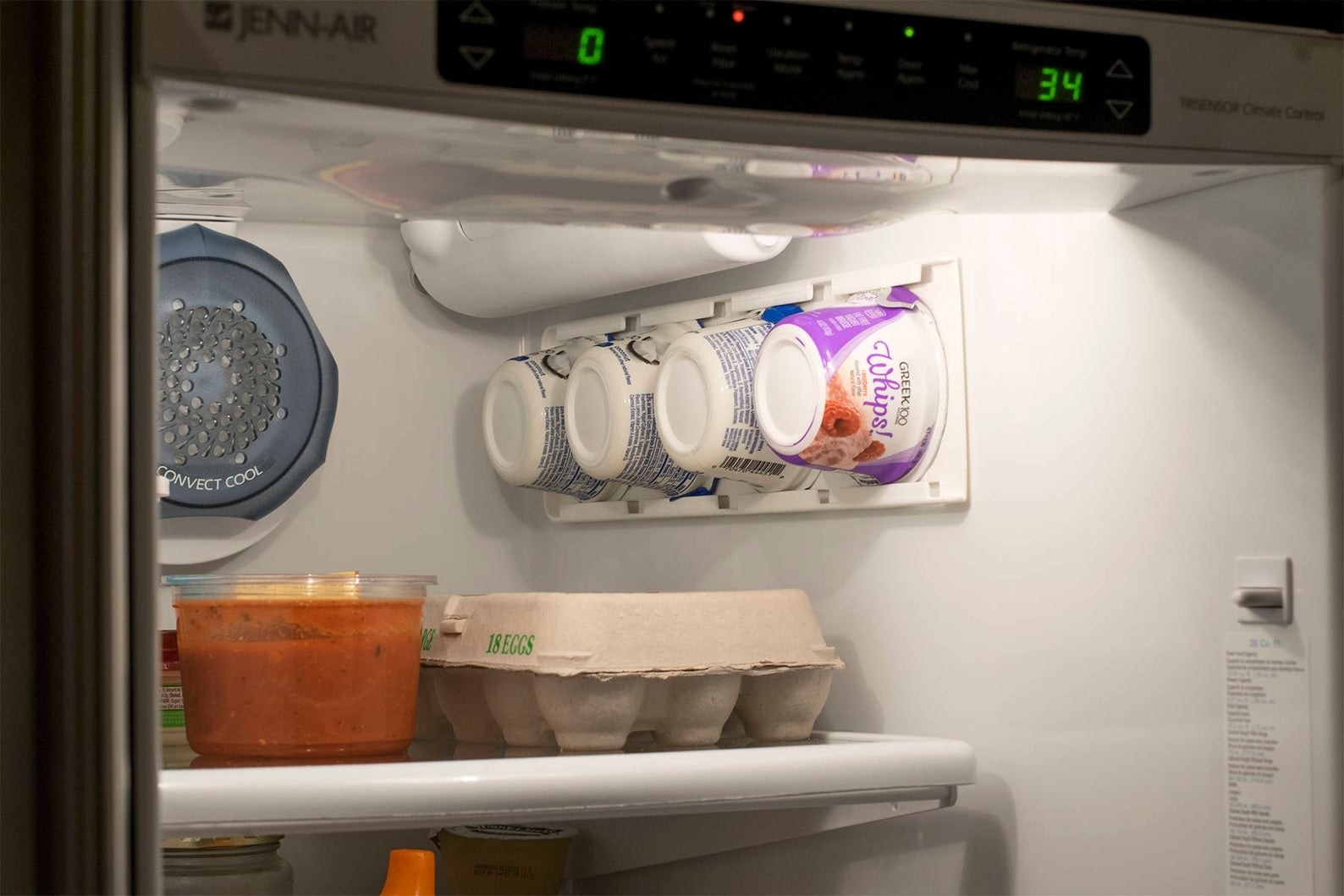 open fridge with wall mounted storage for yogurt cups