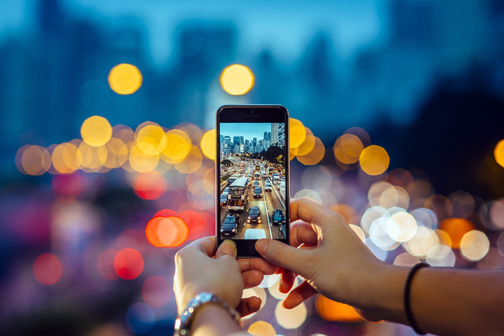 Personne capturant une scène de circulation à l’heure de pointe avec un téléphone intelligent.