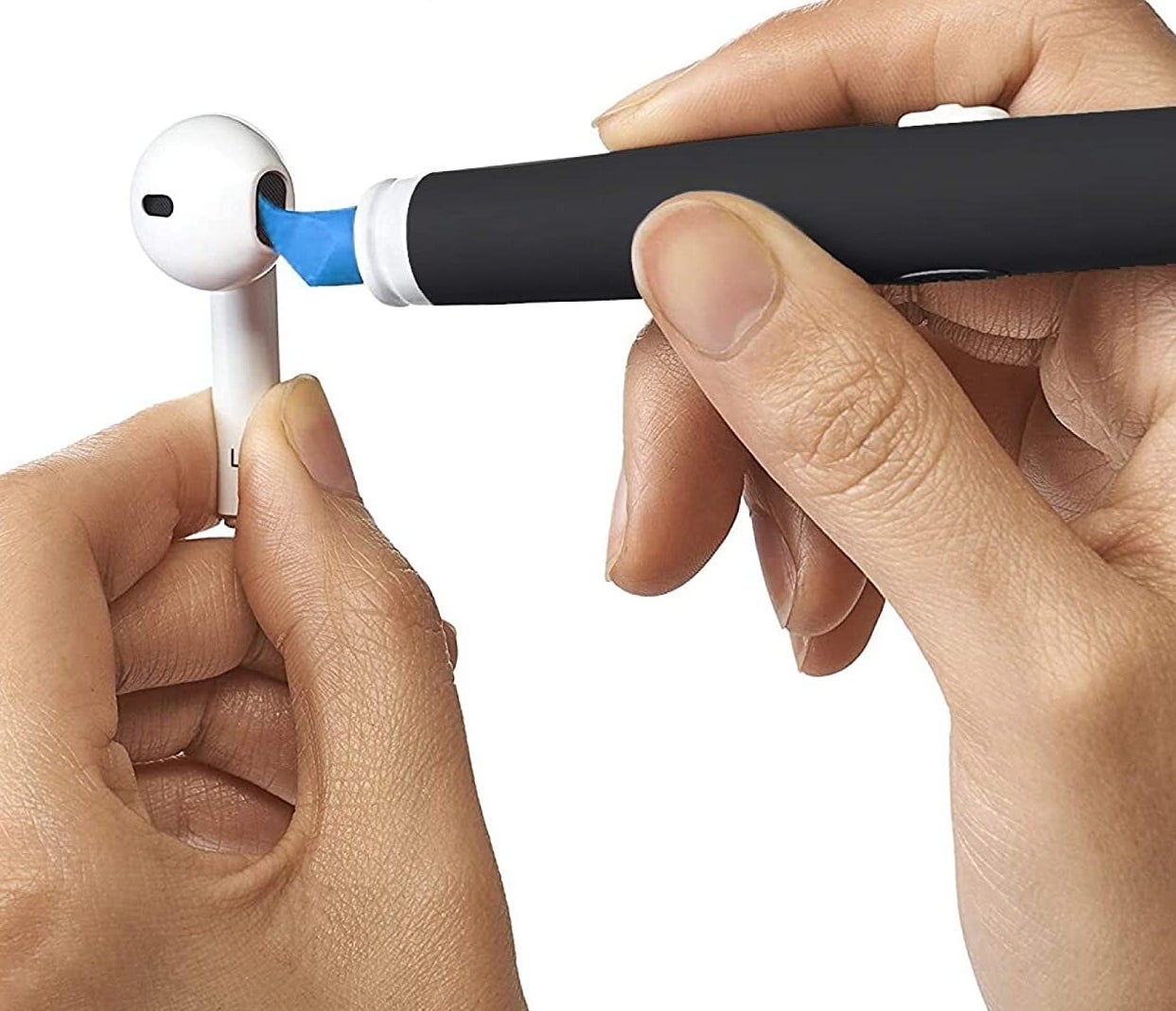 a person using the pointed end of the brush to clean an earbud