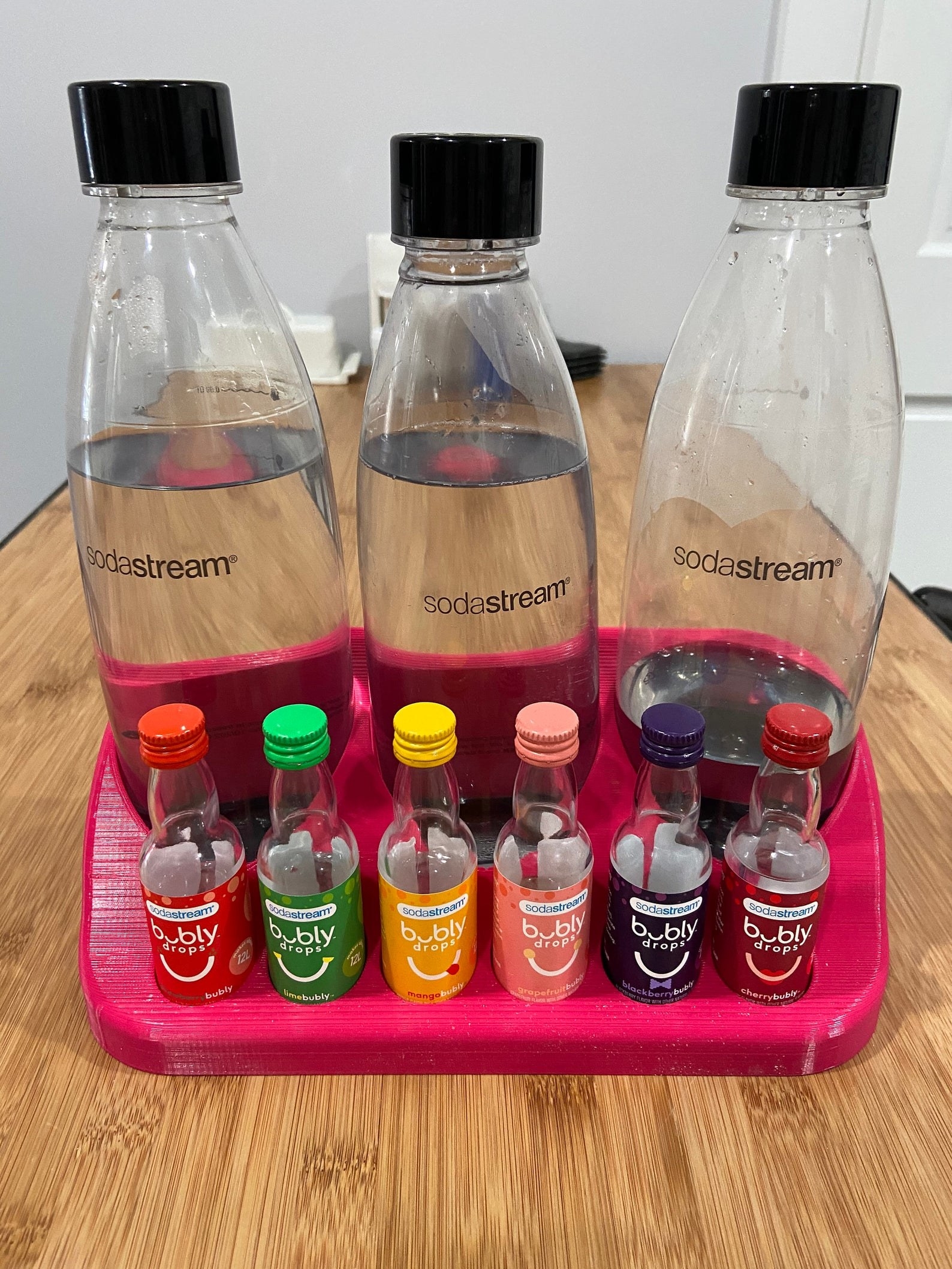 holder with three sodastream bottles and six flavor bottles