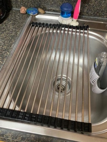 Reviewer's picture of the rolled-out drying rack on their sink