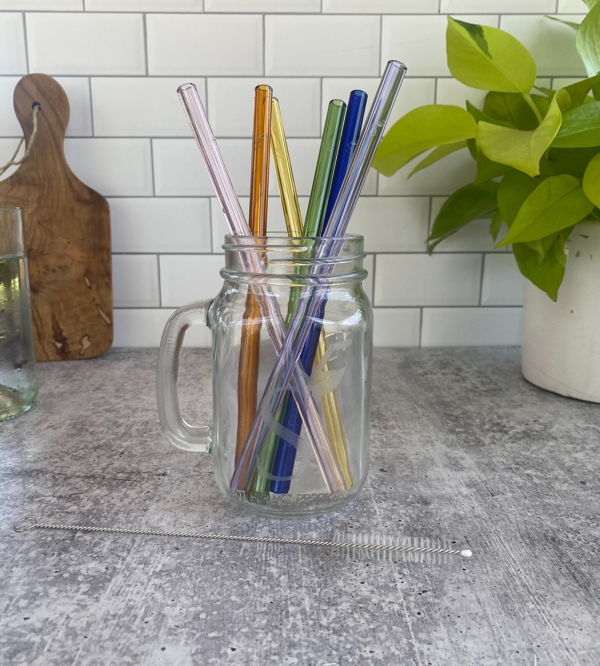 a set of six rainbow-colored straws in a mason jar with a handle